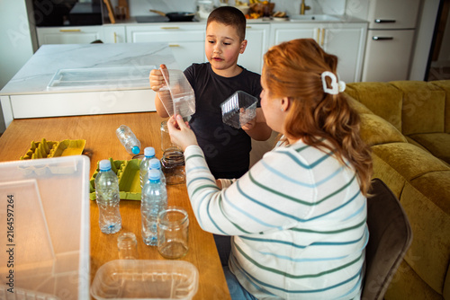 Mother and son sorting recyclables at home kitchen table