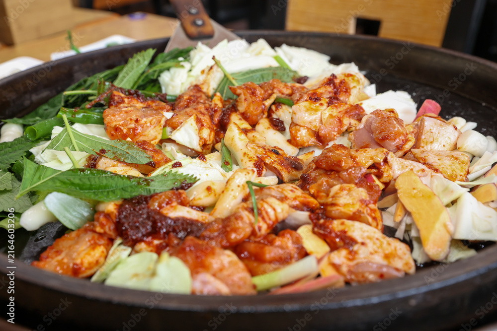 Fototapeta premium Spicy Korean Chicken Stir Fry Dakgalbi with Vegetables on Iron Pan