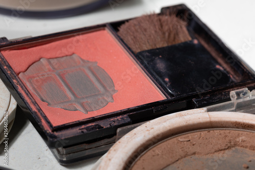 Fotografía Macro close-up of a partially used pink coral blush palette, powder dust and a worn brush suggestive of real-use hygiene, shelf-life cues, and need for replacement in everyday makeup routines