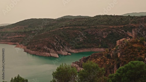 Vibrant teal water and ancient stone ruins in Pyrenees National Park.