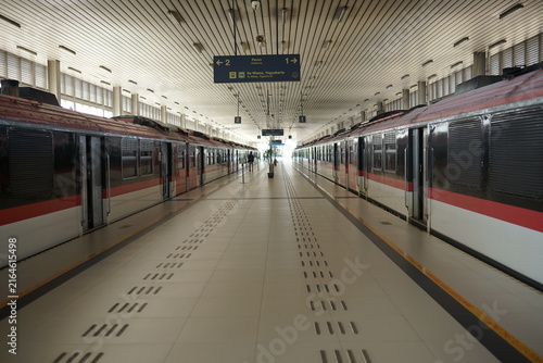 Fotografie Symmetrical perspective of a modern train station platform with passenger trains