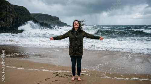 Woman Embracing Nature on Stormy Beach Beach Stormy Weather Ocean Nature Freedom Happiness Outdoors. Concept featuring beach, stormy weather, ocean, nature, freedom for professional commercial design.
