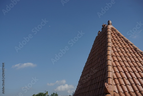 Canvastavla Terracotta tile roof corner against a clear azure sky, showcasing traditional ar