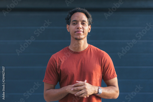 young man of mixed race stands outside in a relaxed way