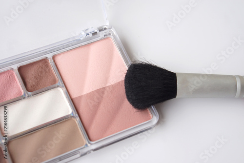 Fotografie Close-up of a pink and neutral makeup palette with a soft blush brush on a clean white background, showcasing beauty cosmetics, makeup application, and feminine color tones