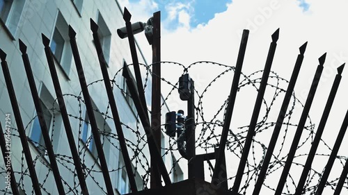 building site surrounded by tall spikes and barbed wire. Security cameras are placed strategically to monitor the area for safety and protection