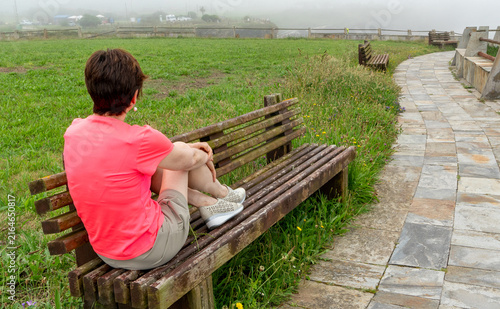 Foto Woman relaxing on bench contemplating nature in fog