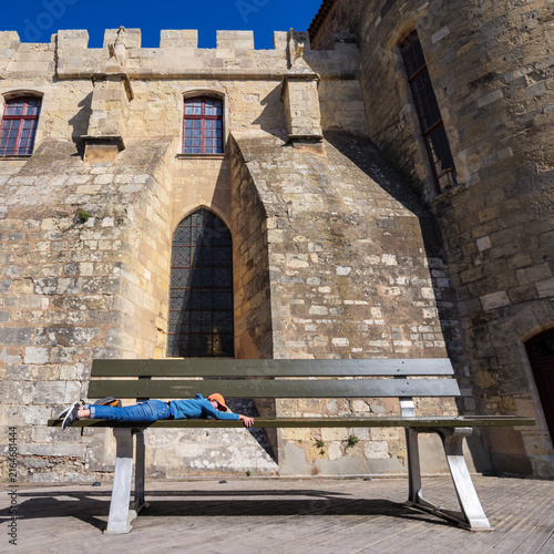 Young Tourist Climbing Onto Giant Bench By Medieval Wall