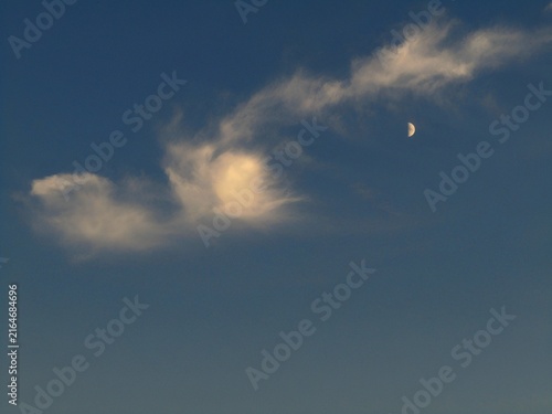 moon and clouds in the sky at dusk 