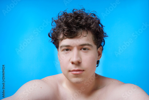 Young man looking at camera on blue background