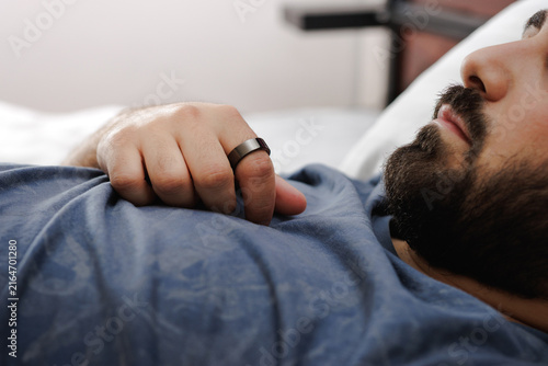 Canvastavla A Man sleeping with a smart ring on his finger