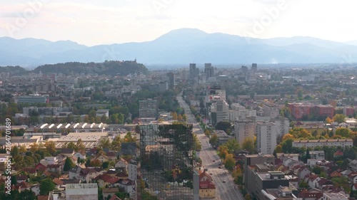 The aerial view shows Ljubljana, the capital city of Slovenia, with buildings and hills on a clear day.
