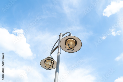 Street lamps against sky with clouds