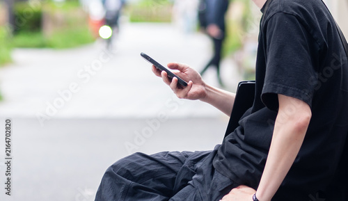 街中でスマホを見る若い男性