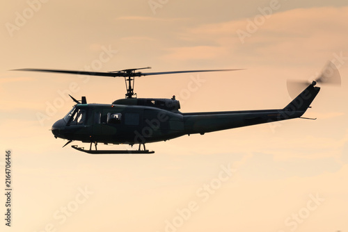 A Bell UH-1 Huey military helicopter during a beautiful sunset. 