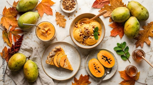 Pawpaw fruit dessert spread with ice cream, pie slice, and smoothie on autumn leaves perfect for National Pawpaw Day