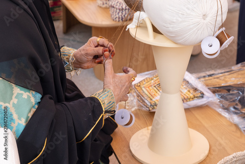 senior woman hand weaves talli craft using kajuja pillow. skilled artisan demonstrates talli craft technique with special ring. traditional talli craft preserves cultural heritage