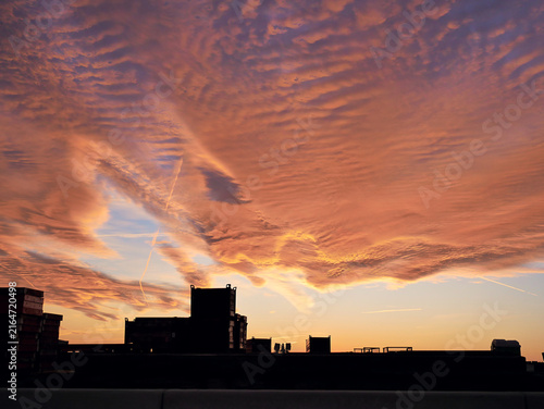 Fotografie Orange and red sunset sky with glowing clouds, dramatic evening atmosphere and colorful cloudscape background