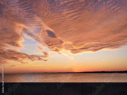 Fotografie Orange and red sunset sky with glowing clouds, dramatic evening atmosphere and colorful cloudscape background