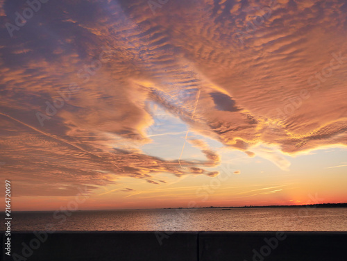Картината върху платно Orange and red sunset sky with glowing clouds, dramatic evening atmosphere and colorful cloudscape background