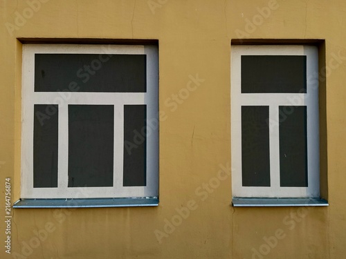 Cuadro en lienzo Trompe l'oeil painted fake windows adorn a smooth yellow building facade, creating a realistic visual illusion