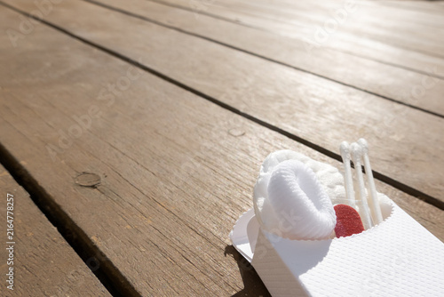Hotel guest care kit with personal hygiene essentials. Cotton pads, cotton buds, hair band and nail file arranged in a small paper packet, representing hospitality service and travel essentials