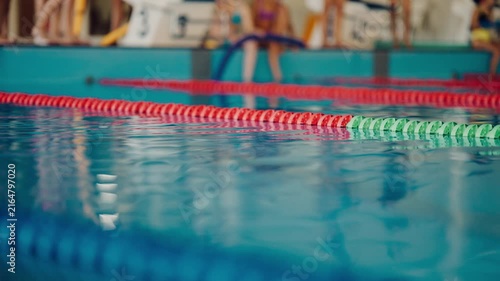 Swimmers prepare for a race at an indoor swimming pool in the afternoon