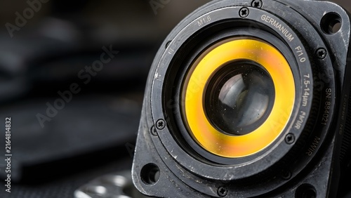Close-up of a germanium lens for an infrared camera, showing intricate details and markings.