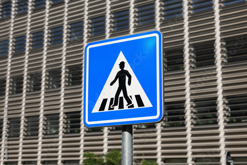 Pedestrian crossing road sign in the Czech Republic. Information symbol at crosswalk in a city. Car drivers should be aware of people on the street.
