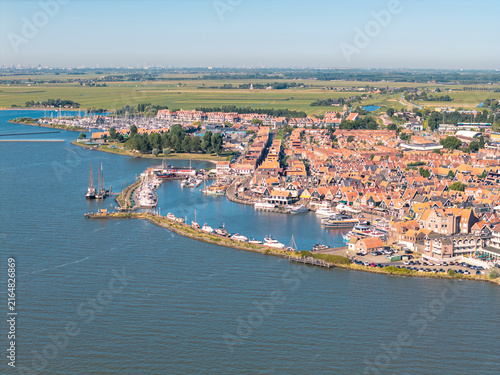 Fotografie Volendam harbor framed by boats and orange rooftops