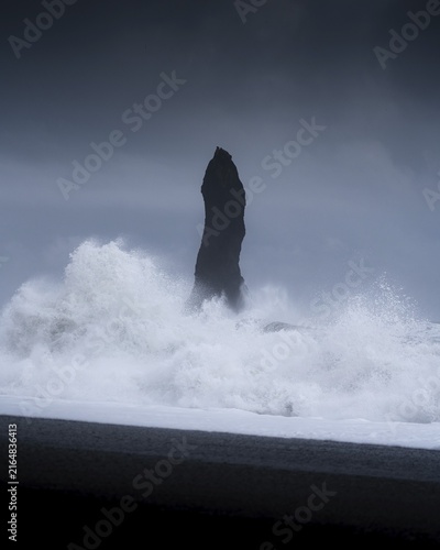 Sharp rock with strongly breaking waves on a volcanic beach, Vik, Iceland