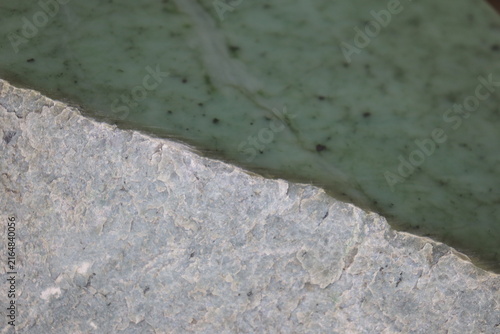 Close-up of a nephrite jade from Quebec. Green stone background and jade. Raw and polished jade. Geology science and mineral from Quebec.
