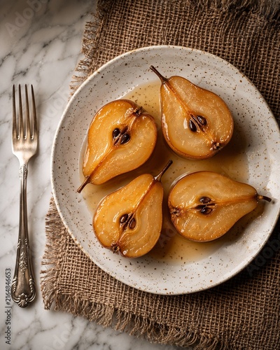 Sliced poached pears on a plate with spices and fork  