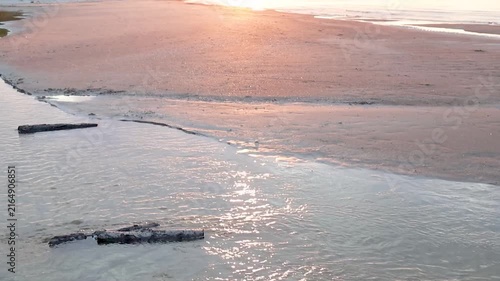 Beautiful sunset at twilight over the sea from a sandy beach. Peaceful coastal landscape with warm evening colors, soft golden light, calm waves, and a tranquil atmosphere