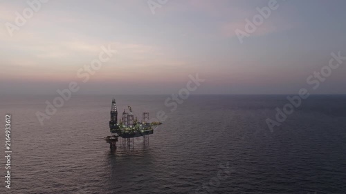 Offshore drilling rig - jack up and offshore platform during sunset for oil and gas exploration and production. 