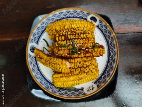 Crispy fried corn tossed with spicy chili powder served on an aesthetic ceramic plate, delicious savory snack and Mexican street food concept.