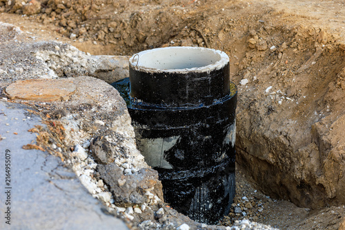 New concrete pipe installed in dirt trench