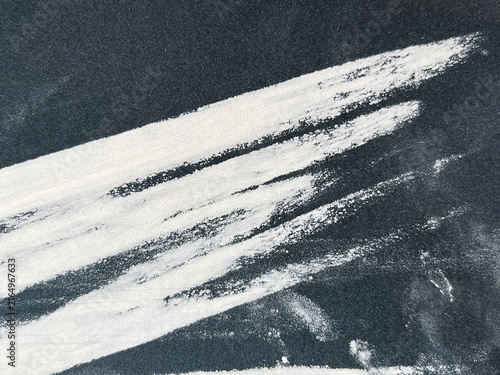 Canvas Print Abstract white chalk brush strokes and smudges on dark sandpaper texture backgro