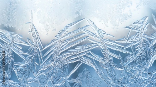 Macro view of intricate crystalline ice frost patterns on a cold winter window glass surface.
