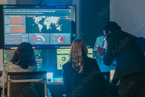Cybersecurity team monitoring security information and event management dashboard in dark war room