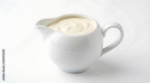 White creamer pitcher filled with light cream dairy