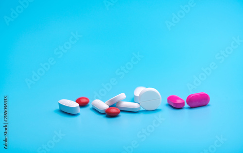 Foto White and pink tablets pills on blue background