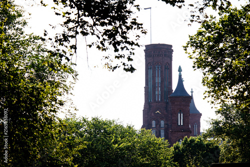 Photography Smithsonian Castle and museums on the National Mall with green lawn and Washington Monument in background, DC, USA