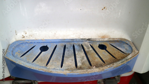 Foto Dirty water cooler dispenser drip tray with grime and mold accumulating, needing