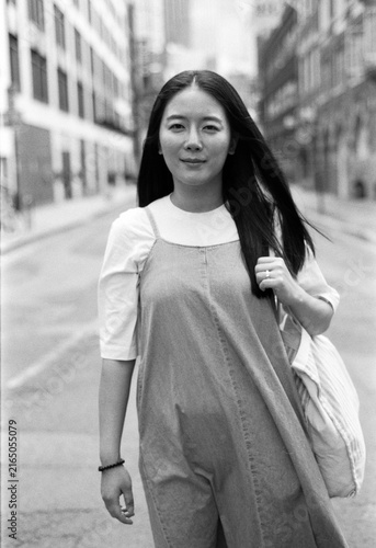 Sticker Young woman walking city street with analog film grain