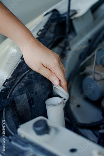 Close up of a hand of woman is checking a liquid coolant pot