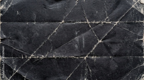 Heavily creased and worn black paper texture with white fold lines showing aged distress.