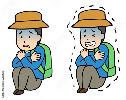 登山中に疲労と寒さで座り込んで震える男性
