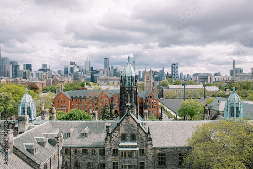 Photography Trinity College Chapel with Toronto skyline and clouds