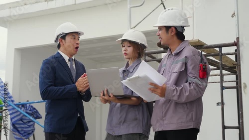 Construction inspector helmet laptop clipboard blueprint discussion teamwork safety building site engineer professional planning architecture project industrial worker business meeting communication